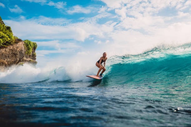 Surf girl on surfboard. Woman in ocean during surfing. Surfer and ocean wave