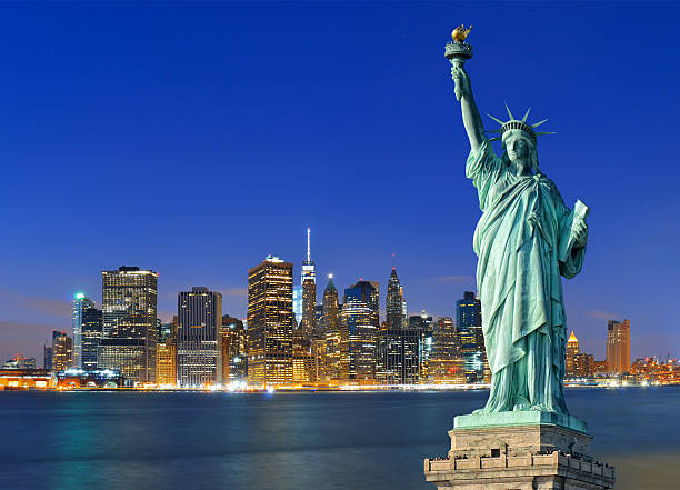 Manhattan skyline at night and Statue of Liberty.