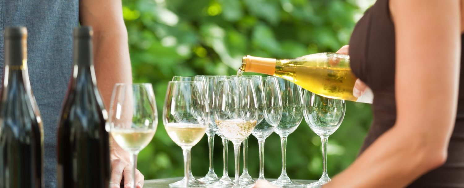 Bartender pouring white wine.GettyImages e1517366603689 1500x609 1